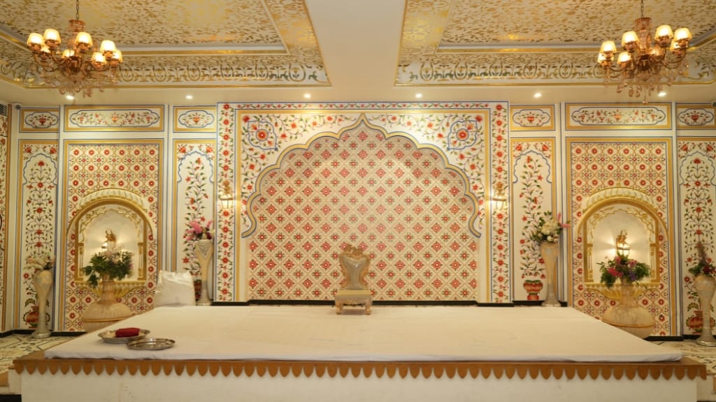 A royal Rajasthani wedding stage setup featuring gold leaf ceilings and traditional floral backdrops, designed by a professional Wedding Planner Company in Jaipur.